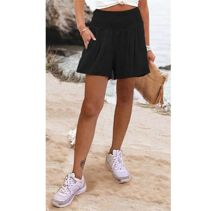 Woman wearing Glow Chic's high waist shorts on the beach.