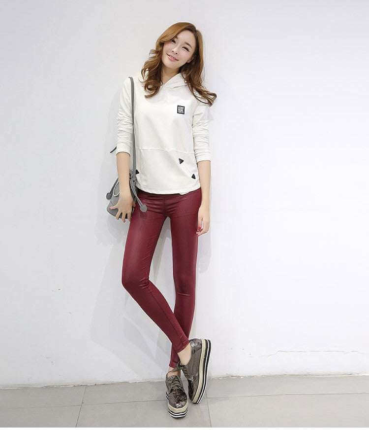 Women's red faux leather leggings styled with a casual white top.