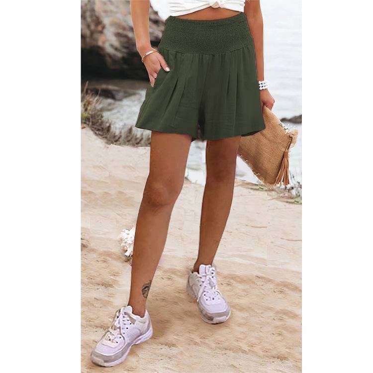 Woman wearing Glow Chic's high waist shorts in green, paired with sneakers, outdoors.