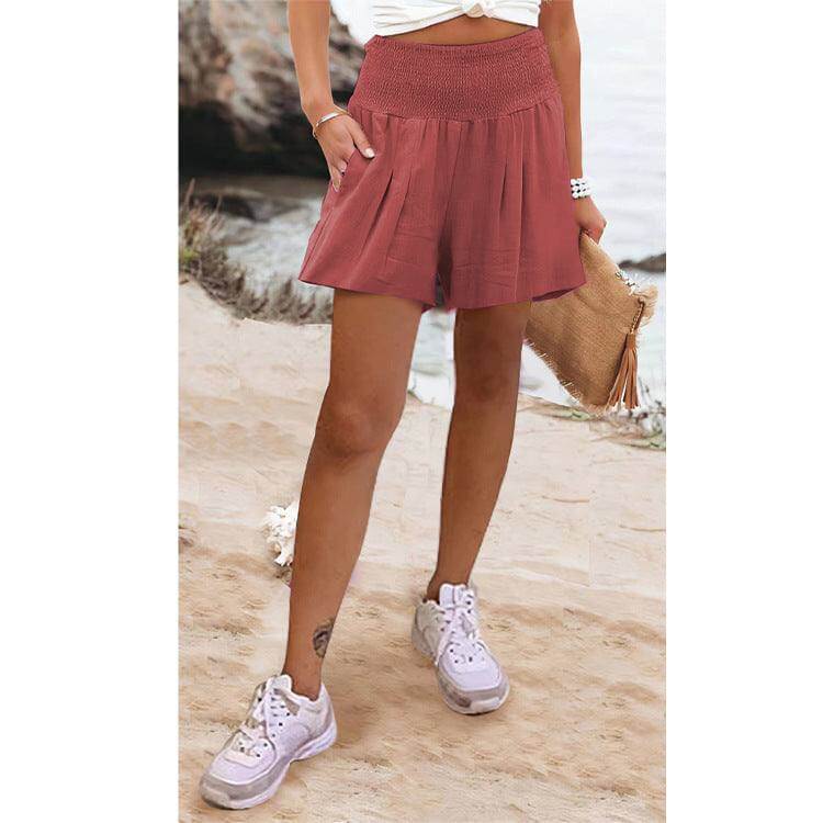 Woman wearing Glow Chic's High Waist Shorts on a beach.